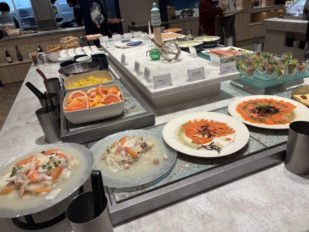 夕食ビュッフェの海鮮カルパッチョやフルーツが並んでいます